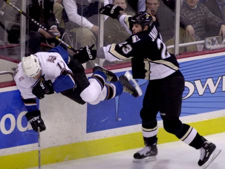 Penguins John Jakopin checks Capitals Chris Simon into the boards